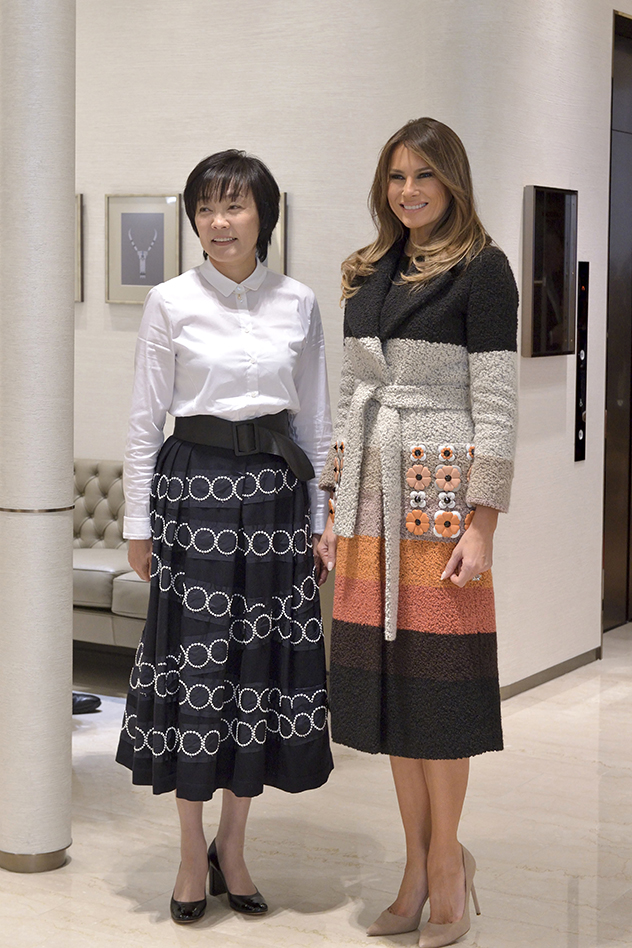 מלניה בשמלת מעיל של פנדי עם אשת ראש ממשלת יפן, באמצע מסע שופינג של פנינים (צילום: David Mareuil/Pool Photo via AP)